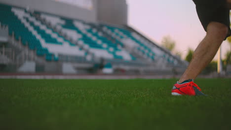 Stellen-Sie-Den-Fußball-Auf-Die-Rasenbahn-Und-Schlagen-Sie-Den-Ball-Im-Stadion-Mit-Grünem-Rasen.-Ein-Professioneller-Fußballspieler-Kickt-Den-Ball-In-Zeitlupe